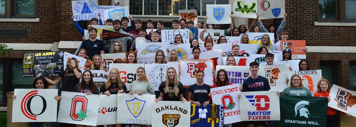 Students holding up signs during the Class of 2024 Decision Day.